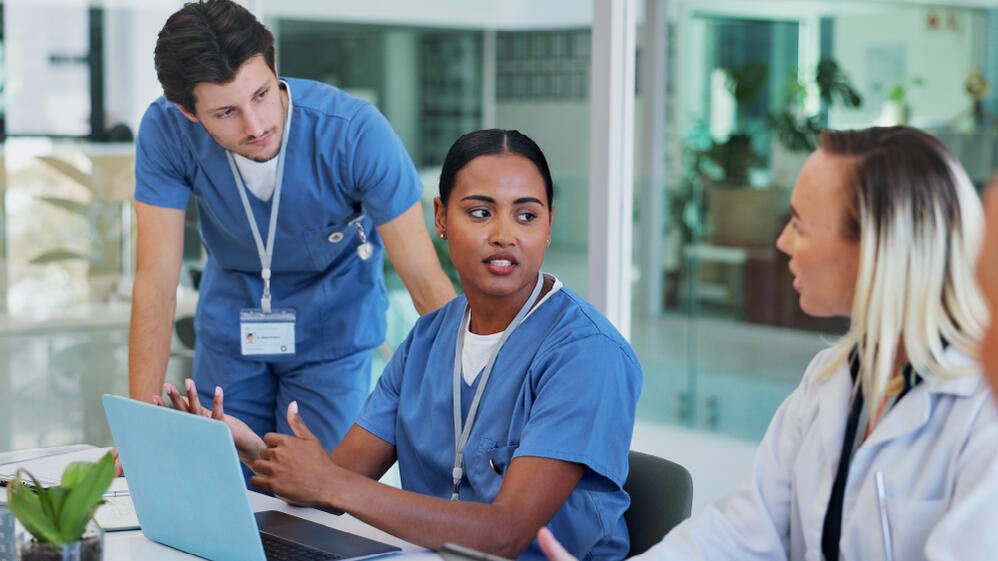 Three pharmaceutical scientists in scrubs discussing the ambiguous results of a clinical trial.